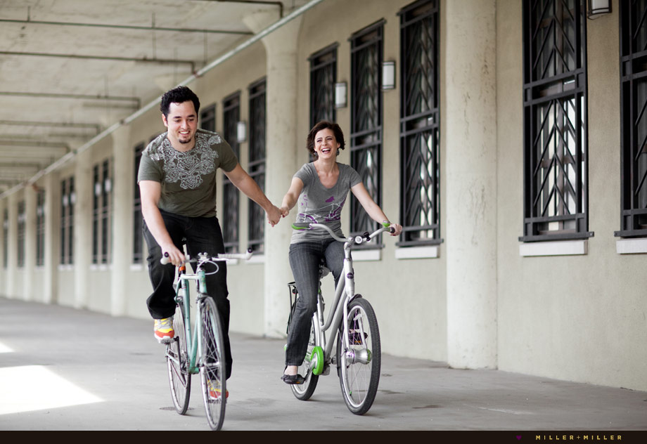biking holding hands engagement couple biking holding hands engagement couple