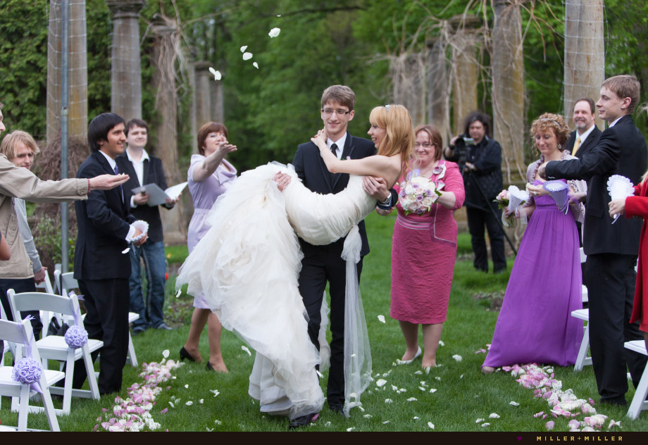 throwing rose petals recessional groom carries bride