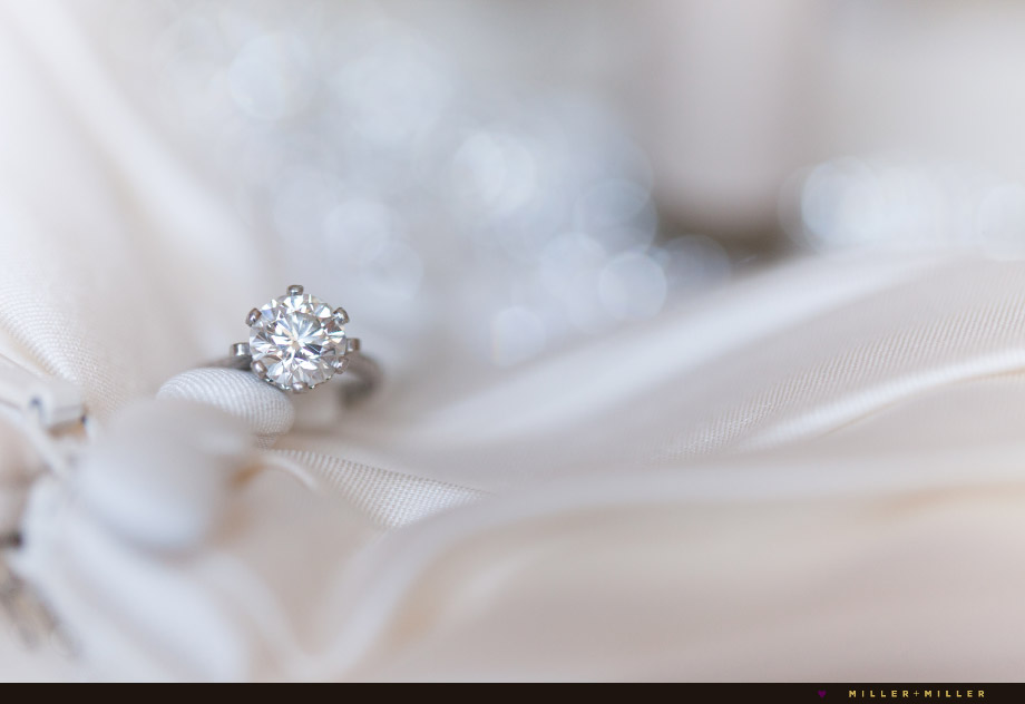 round diamond ring photographed on gown buttons